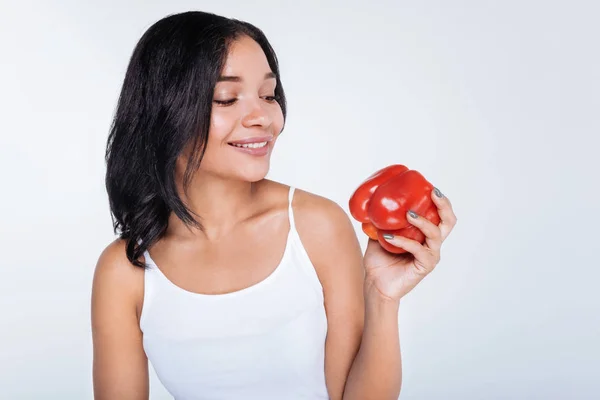 Woman looking at red bell pepper — Stock Photo, Image