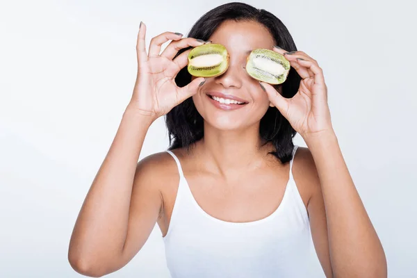 Woman posing with kiwifruits near her eyes — Stock Photo, Image
