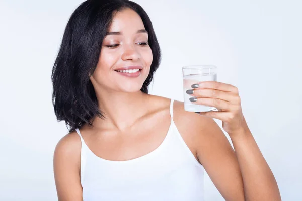 Mujer alegre sosteniendo un vaso de agua — Foto de Stock