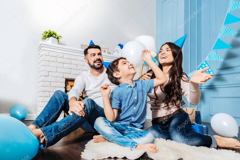 Happy young family throwing balloons