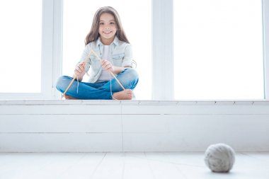 Örgü iğneleri ile oynayan sevimli güzel kız