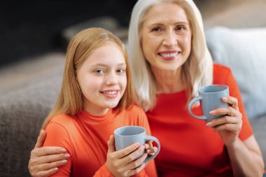 Pozitif güzel büyükanne ve torunu bardak tutan