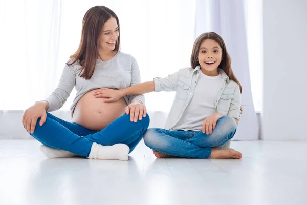 可爱的惊喜女孩感觉婴儿动作在妈妈的肚子 — 图库照片