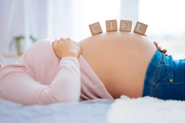Hamile kadının karın üzerinde bulunan ahşap küpleri — Stok fotoğraf