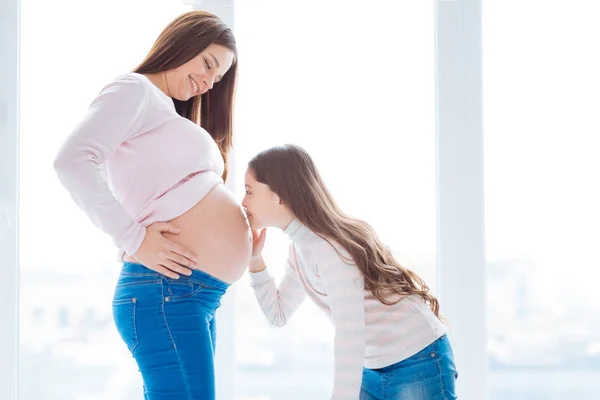 Sevimli küçük kız ve hamile kadın bebek karın hakkında — Stok fotoğraf