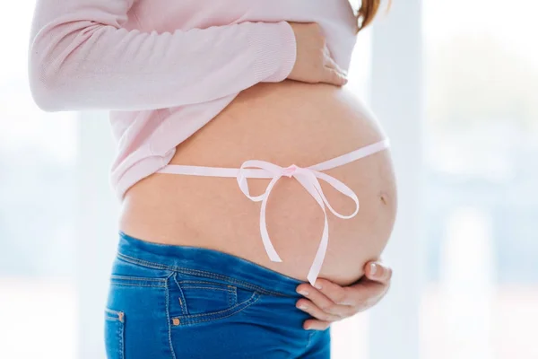 怀孕的少妇拥抱她的腹部用丝带 — 图库照片