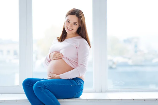 Mujer embarazada elegante sonriendo a la cámara — Foto de Stock