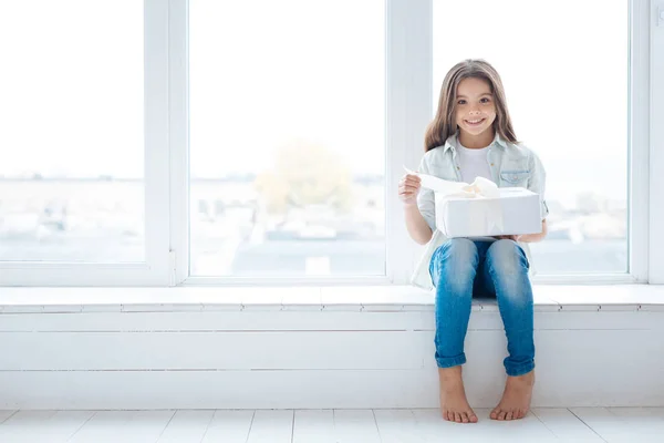 Inspired amazed girl unwrapping her gift — Stock Photo, Image