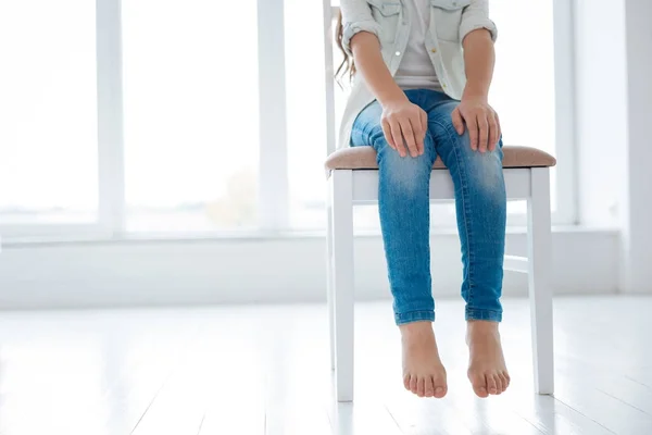 Petite fille assise sur la chaise blanche — Photo