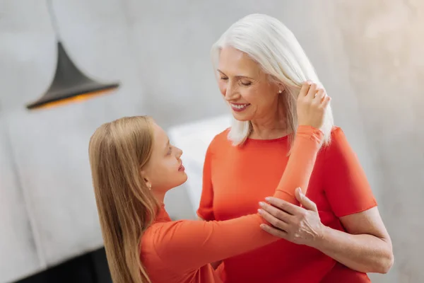 Glad ung flicka tittar på hennes farmors ansikte — Stockfoto