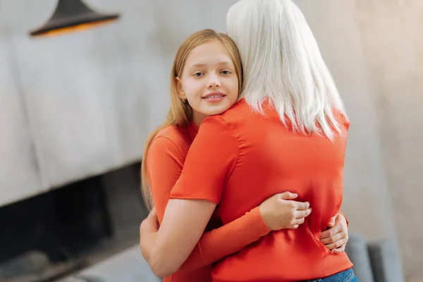 Trevlig trevlig flicka kramar hennes mormor — Stockfoto