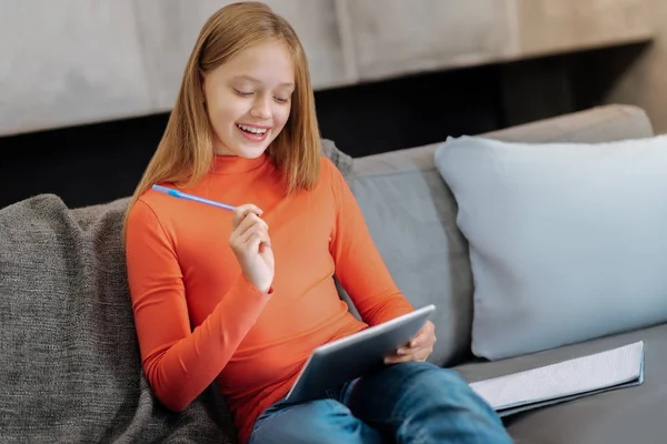 Menina feliz alegre usando um tablet para estudar — Fotografia de Stock