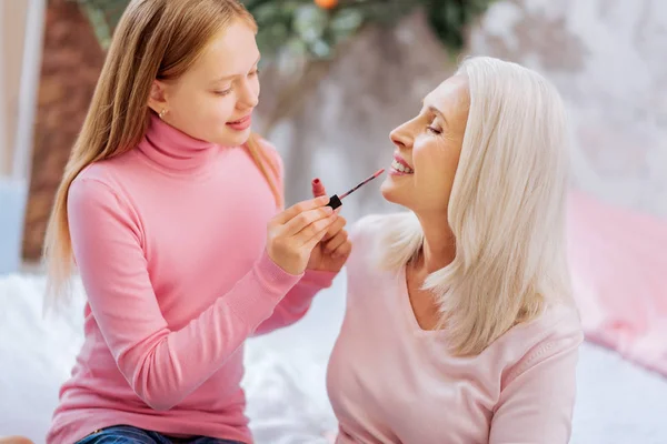 Mooi mooi meisje houdt een lippenstift borstel — Stockfoto