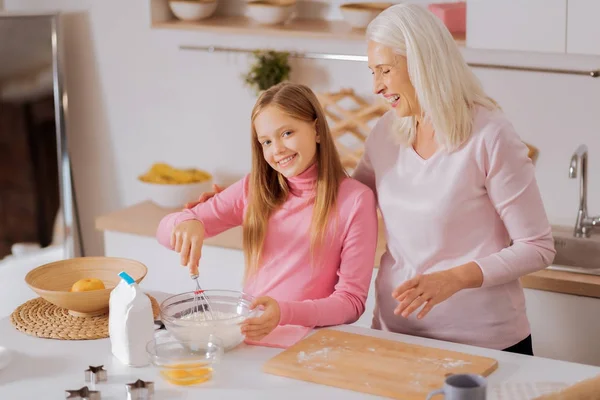 Fröhliches junges Mädchen lernt kochen — Stockfoto