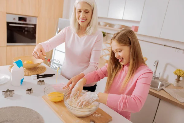 Menina feliz alegre colocando as mãos na farinha — Fotografia de Stock