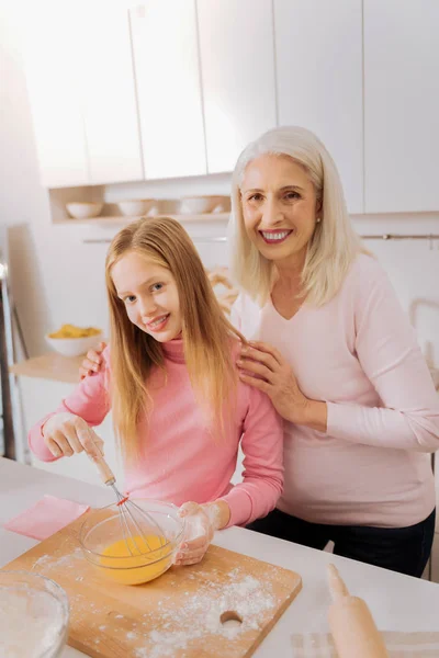 Trevlig äldre kvinna håller hennes barnbarn axlar — Stockfoto