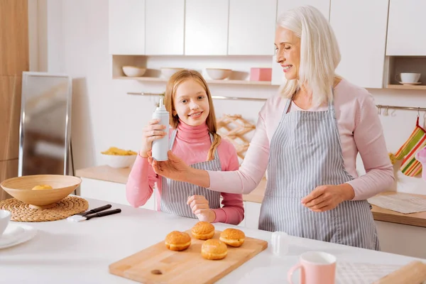 Joyful elderly woman taking a bottle