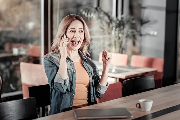 Emocional jovem mulher olhando animado ao falar ao telefone — Fotografia de Stock