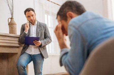 Düşünceli erkek psikolog sorun hakkında düşünme