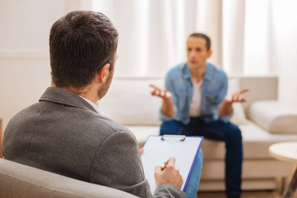 Mannelijke ernstige psycholoog luisteren naar zijn patiënt — Stockfoto