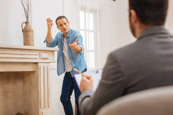 Agradable paciente masculino explicando sus problemas — Foto de Stock