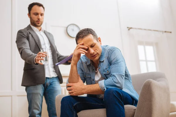 Careful male psychologist proposing water to patient — Stock Photo, Image