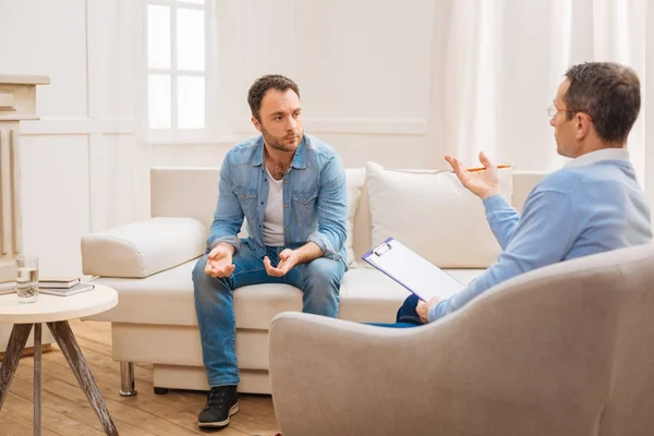 Paciente masculino deprimido escuchando sobre su problema — Foto de Stock