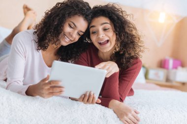Duygusal kız touchpad ekranında bakarken gülümseyen
