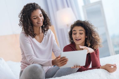 Bir şey dijital tablet üzerinde tartışırken neşeli genç bayanlar