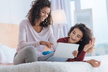 Tablet bilgisayarda bakarken gülümseyen kız fikirli pozitif