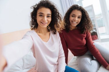 Güzel kıvırcık saçlı kız kendi kendine portre fotoğraf çekmek