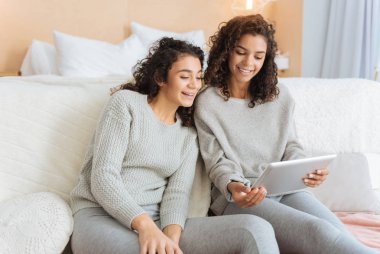 Touchpad ekranında bakarken gülen kızlar fikirli pozitif