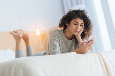 Yatakta yatarken ve mesaj okuma mutsuz genç bayan