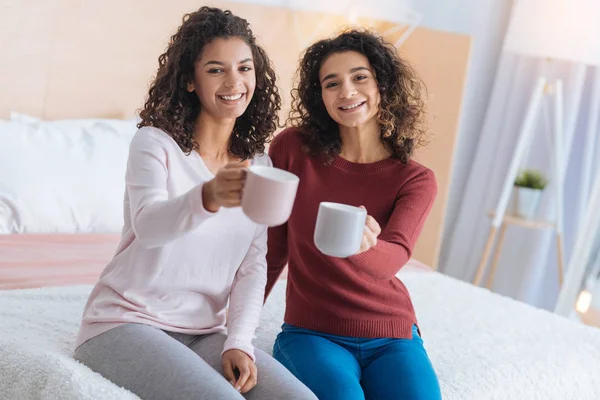 Радостные молодые леди наслаждаются ароматным чаем дома — стоковое фото