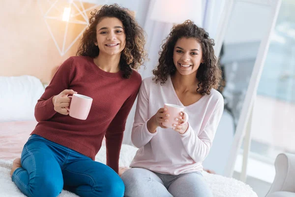 Расслабленные сестры наслаждаются ароматным чаем вместе — стоковое фото
