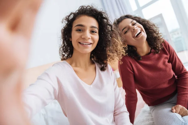 Irmãs radiantes posando para selfie e sorrindo alegremente — Fotografia de Stock