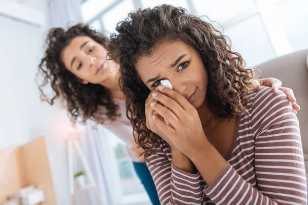 Loving young brunette calming her poor little sister