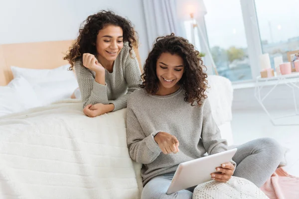 Hermanas de pelo rizado revisando las redes sociales en el panel táctil — Foto de Stock