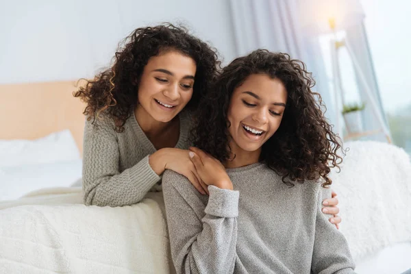 Meninas adoráveis sorrindo enquanto deitado na cama e conversando — Fotografia de Stock