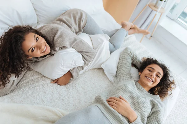 Glada unga damer tar paus och liggande på sängen — Stockfoto