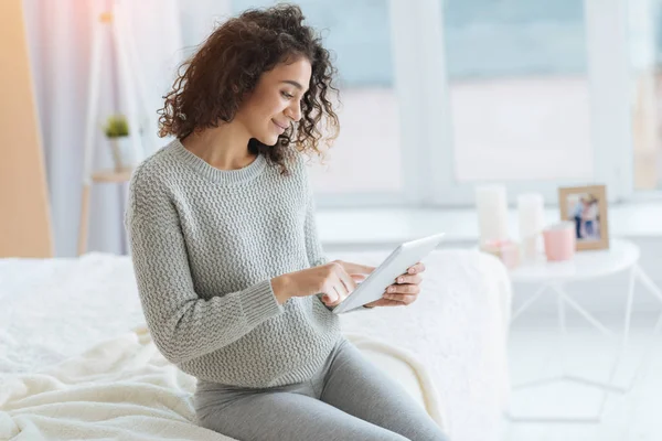 Chica atractiva sonriendo mientras usa la tableta digital — Foto de Stock