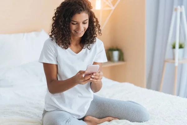 Relajada joven dama leyendo el mensaje por teléfono —  Fotos de Stock