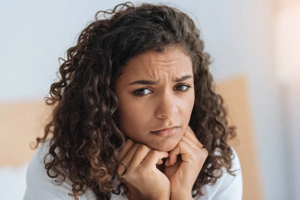Worried curly haired girl looking into camera — Stock Photo, Image