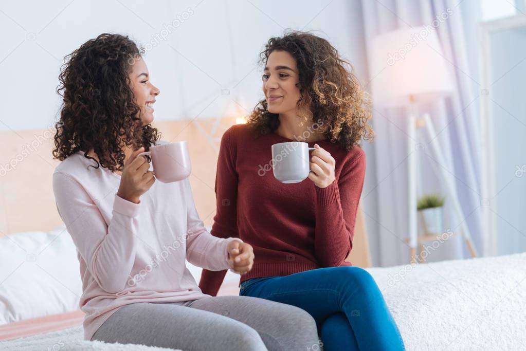 Positive minded girls drinking tea and chatting