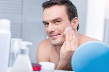 Kurnaz yakışıklı adam yüzünü silerek