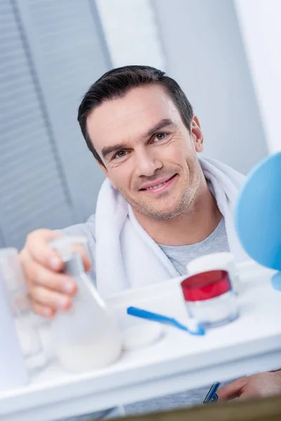 Kraftig energisk man ansöker lotion — Stockfoto