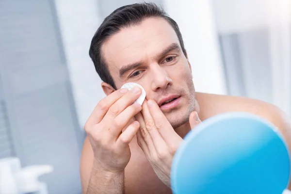 Aufmerksamer ernsthafter Mann blickt in Spiegel — Stockfoto