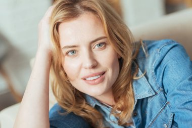 Evde istirahat ederken gülümseyen sevimli güzel kadın