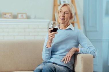 Şarap içme ve mesafe içine bakarak huzurlu yaşlı kadın
