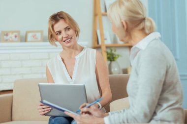 Oturma ve özenli yaşlı müvekkili gülümseyen profesyonel çalışan